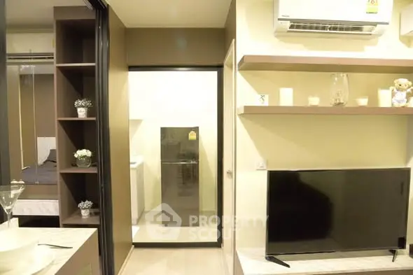Modern apartment interior with TV, air conditioning, and stylish shelving.