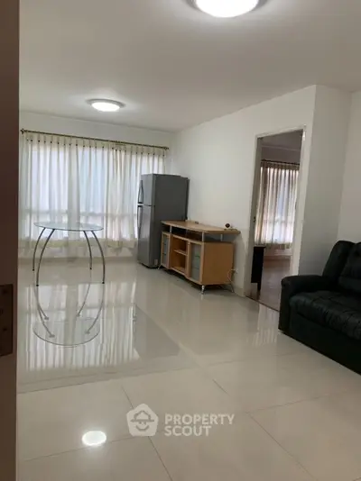 Spacious living room with glossy tiled floors and natural light
