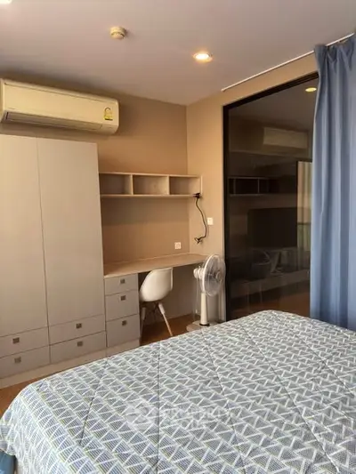 Modern bedroom with air conditioning and study area, featuring a stylish bed and ample storage.