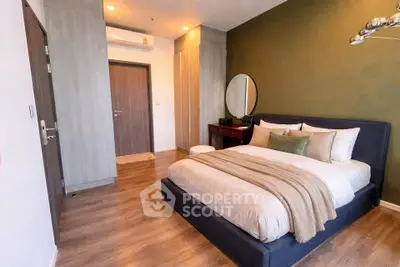 Modern bedroom with stylish decor, featuring a cozy bed, wooden flooring, and elegant lighting.