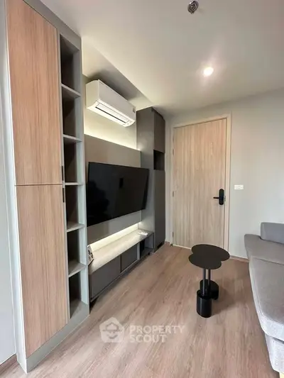 Modern living room with sleek furniture and wall-mounted TV in a stylish apartment.