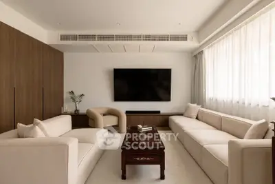 Elegant living room with modern furniture and large TV, perfect for relaxation and entertainment.
