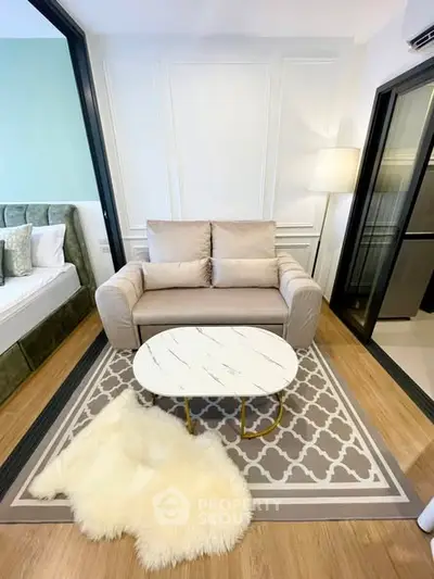 Modern living room with cozy sofa, stylish rug, and elegant decor in a contemporary apartment.