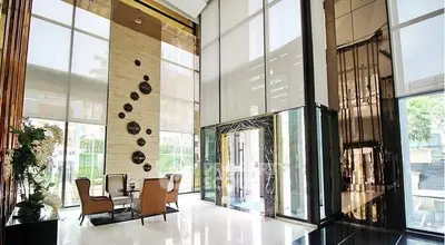 Luxurious high-ceiling lobby with modern decor and elegant seating area in upscale building.