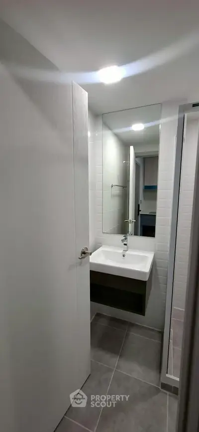 Modern compact bathroom with sleek design and large mirror