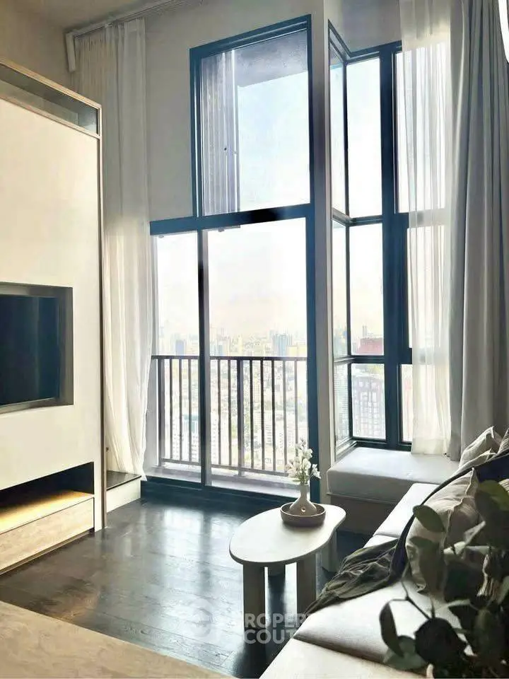 Modern living room with floor-to-ceiling windows and stunning city view.