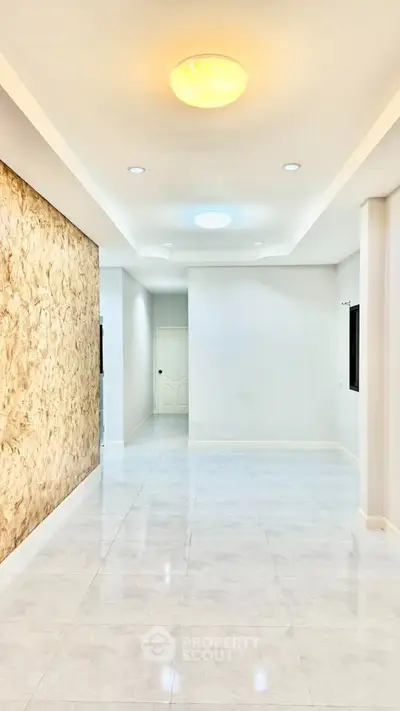 Spacious modern interior with elegant lighting and marble flooring, perfect for stylish living.