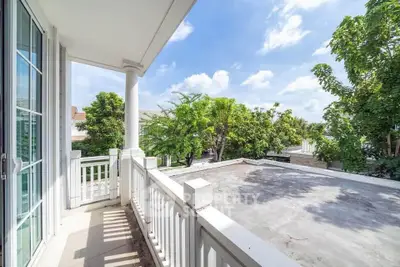 Spacious balcony with lush greenery and clear blue sky view