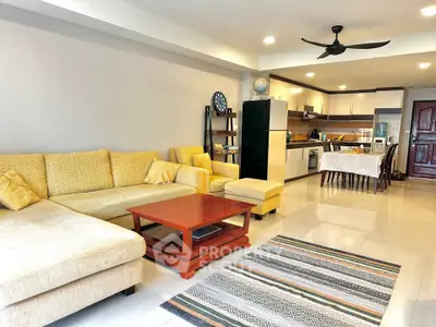Spacious open-layout living room with modern kitchen and cozy seating area.