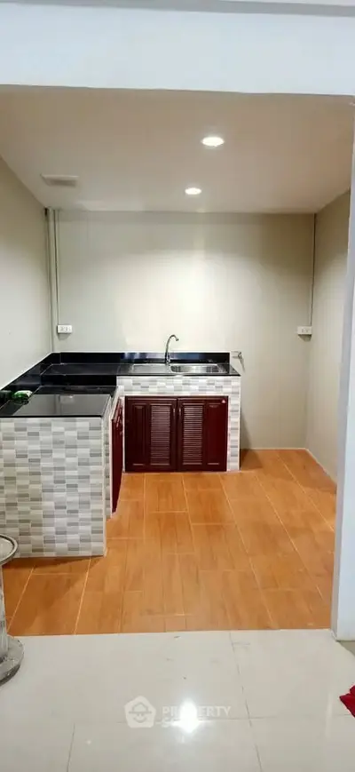 Modern kitchen with sleek countertops and tiled flooring, perfect for culinary enthusiasts.