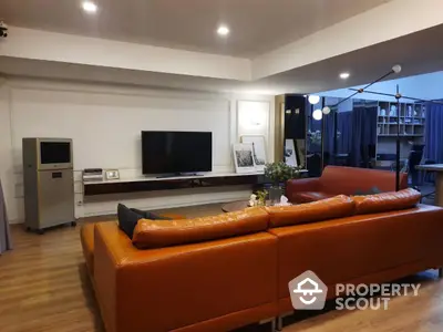 Spacious modern living room with stylish orange leather sofa and sleek decor