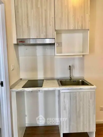Compact modern kitchen with sleek cabinetry and integrated appliances in a stylish apartment.