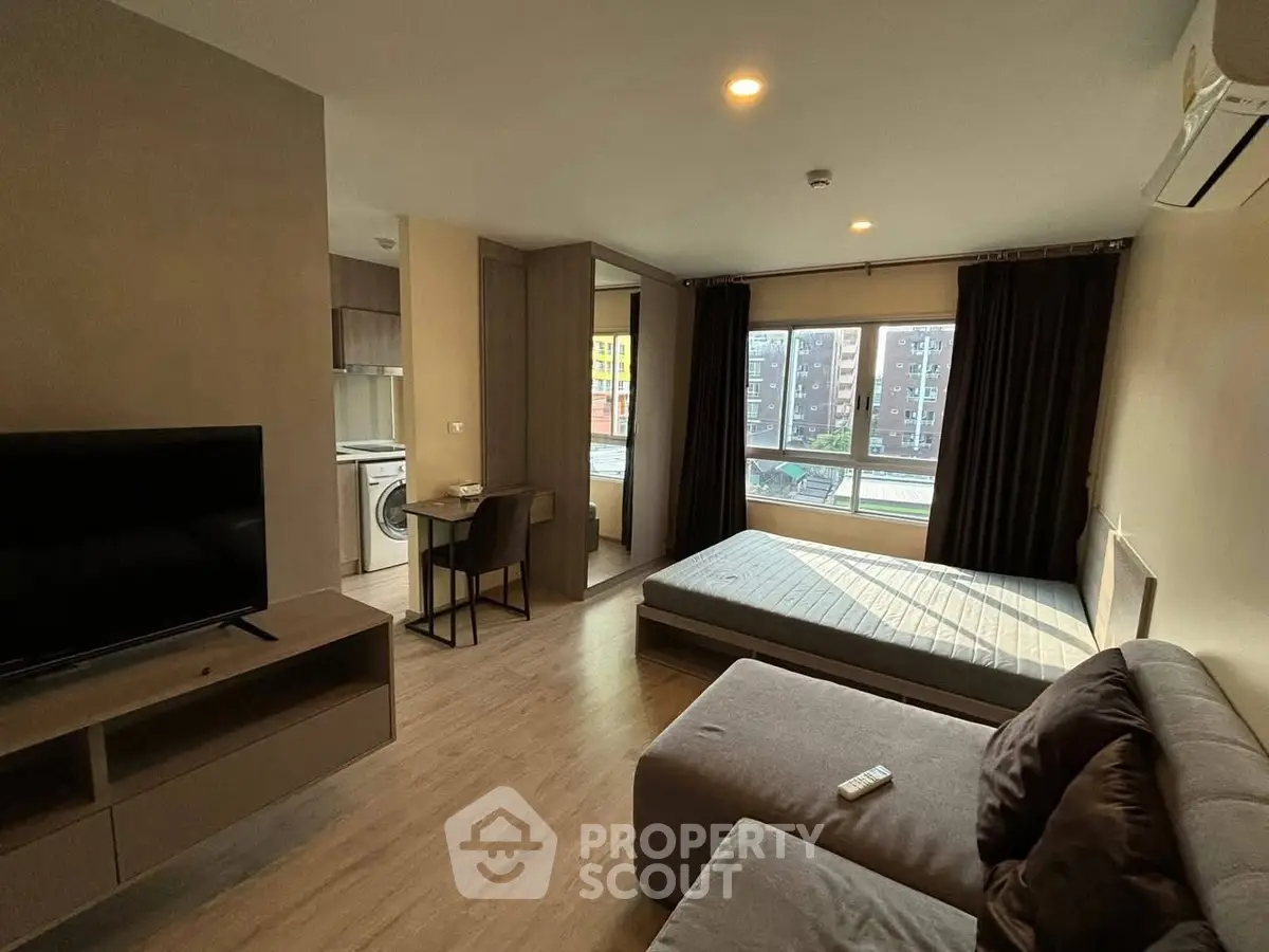 Modern studio apartment with cozy living area and large window view