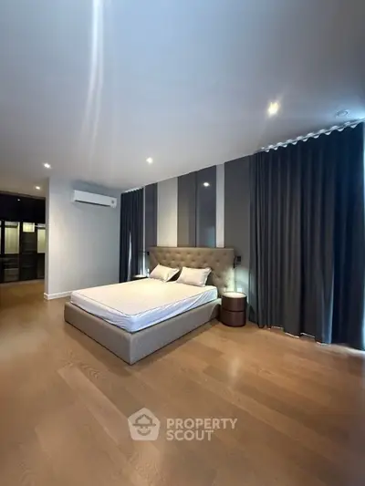 Spacious modern bedroom with elegant decor and ample natural light