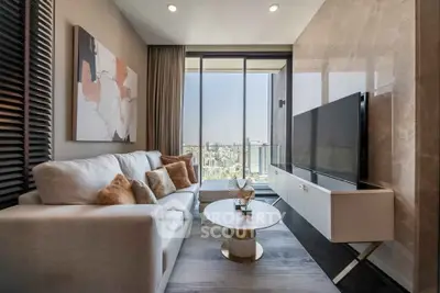Luxurious modern living room with city view, elegant decor, and large flat-screen TV.