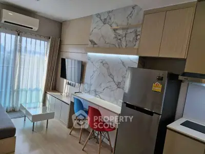 Modern living room with stylish kitchen and marble accents, featuring vibrant chairs and sleek appliances.