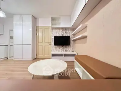 Modern living room with sleek furniture and mounted TV, featuring minimalist design and neutral tones.