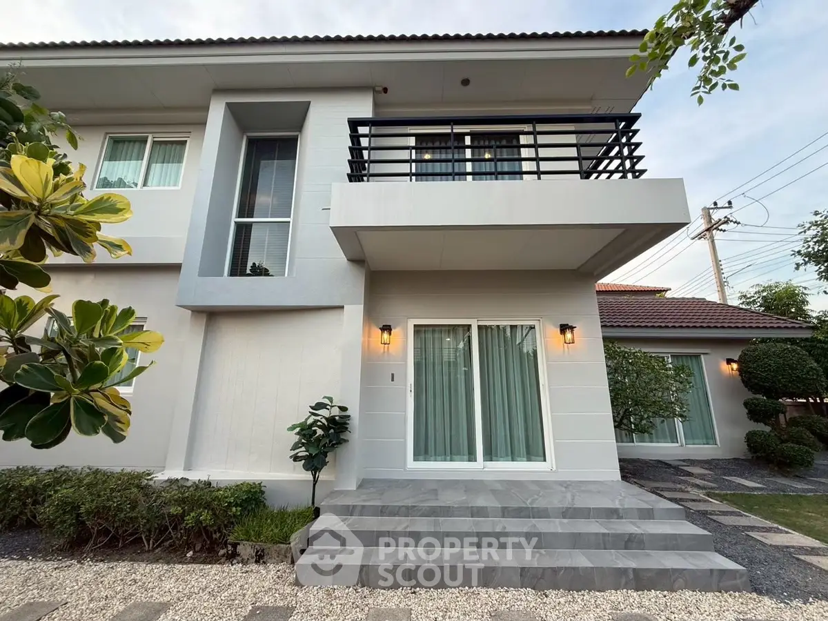 Modern two-story house with balcony and landscaped garden