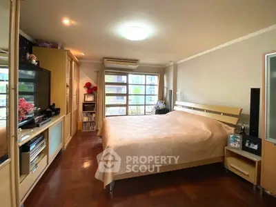 Spacious master bedroom with large windows, ample natural light, and hardwood floors, featuring built-in storage and modern amenities.