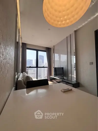 Modern living room with city view, sleek furniture, and ample natural light.