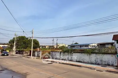 Spacious suburban street view with clear skies and residential surroundings.