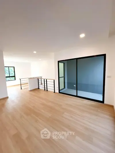 Spacious modern living room with wooden flooring and large windows