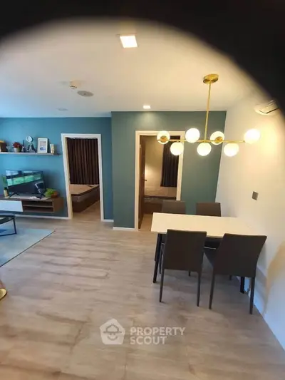 Modern open-plan living room with dining area and stylish lighting in a contemporary apartment.