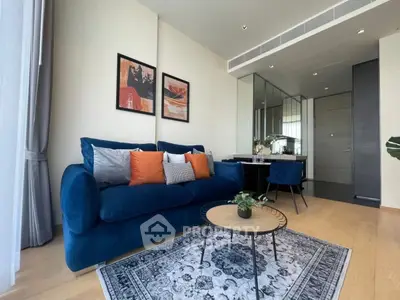 Modern living room with blue sofa, stylish decor, and elegant dining area in a contemporary apartment.