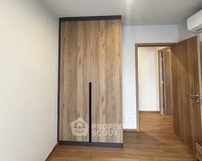 Modern bedroom with wooden flooring and built-in wardrobe