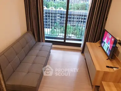 Modern living room with sleek sofa and TV, overlooking a city view from the balcony.