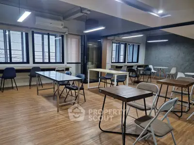 Spacious modern co-working space with ample natural light and stylish furnishings.