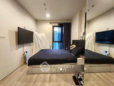Modern bedroom with sleek design and large TV, featuring floor-to-ceiling window for natural light.