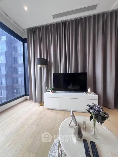Modern living room with floor-to-ceiling windows and stylish decor in a high-rise apartment.