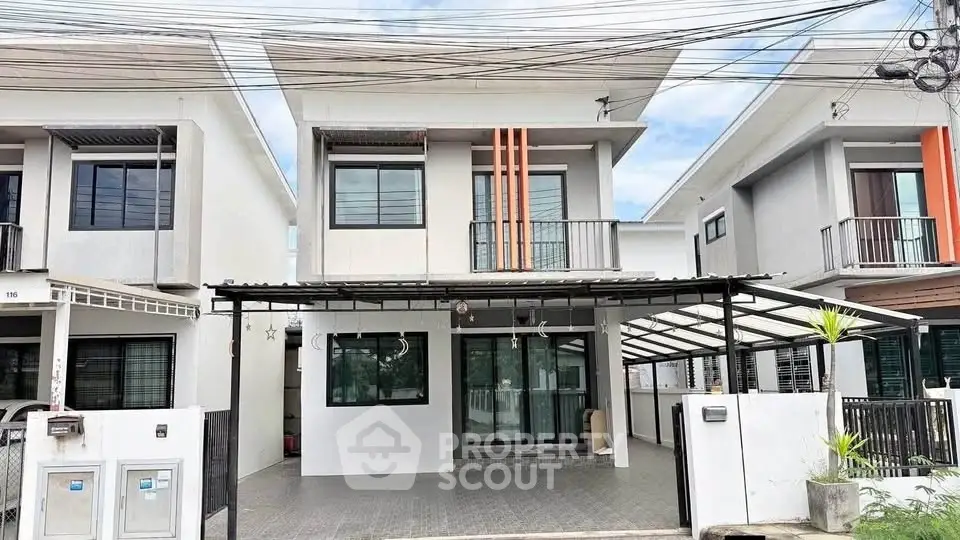 Modern two-story house with carport and sleek design in suburban neighborhood.