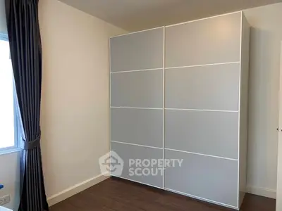 Modern bedroom with sleek wardrobe and elegant curtains