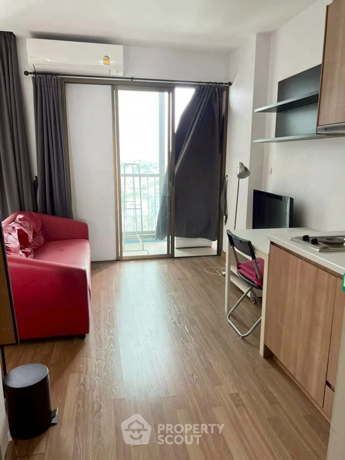 Modern living room with red sofa and balcony view, perfect for urban living.