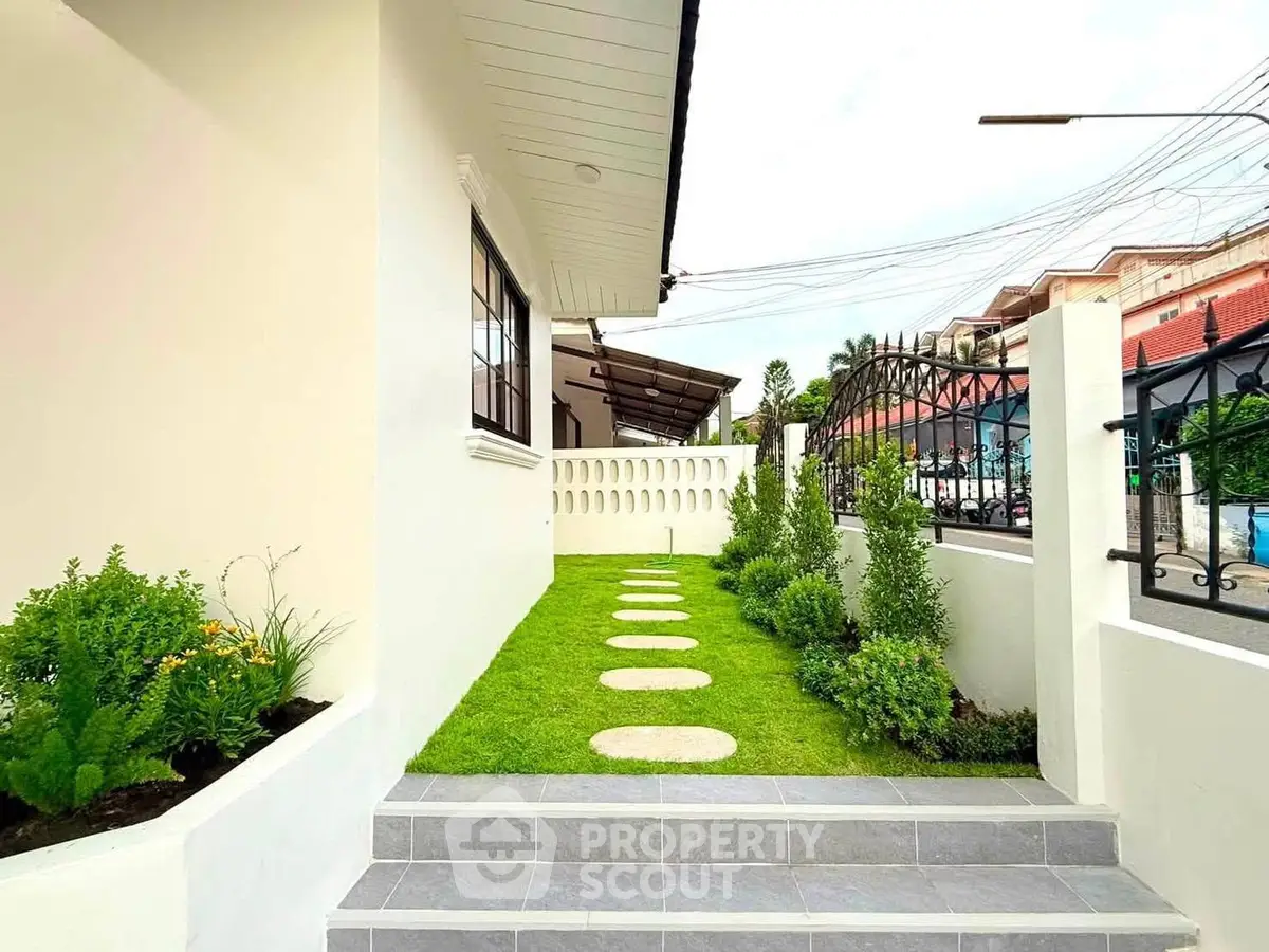 Charming exterior view of a modern home with lush garden and pathway, perfect for serene living.