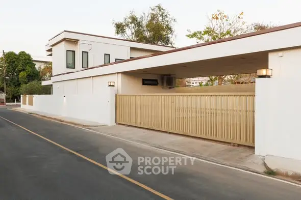 Modern minimalist house exterior with sleek design and spacious driveway.
