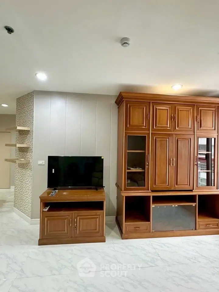 Spacious living room with elegant wooden cabinetry and modern TV setup