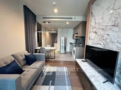 Modern living room with open kitchen, featuring sleek furniture and marble accents.