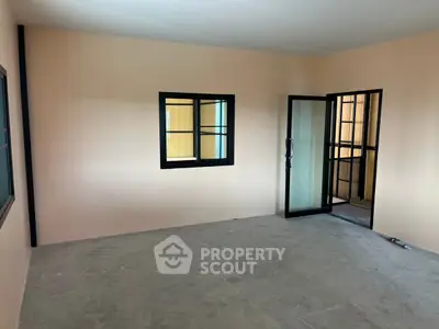 Spacious unfurnished room with large windows and balcony access