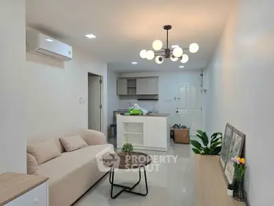 Modern living room with open kitchen, stylish lighting, and cozy seating area in a contemporary apartment.