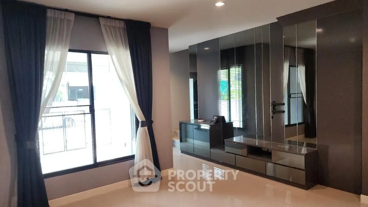 Spacious modern living room with large window and sleek furniture