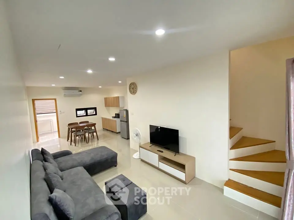 Spacious modern living room with sleek furniture and open kitchen layout