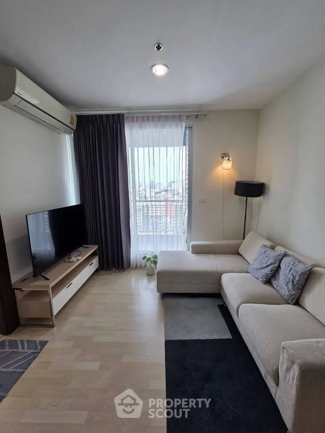 Modern living room with cozy sofa and city view from window