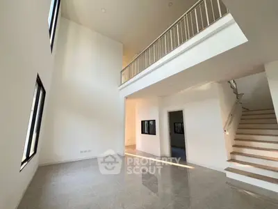 Spacious modern living room with high ceilings and elegant staircase