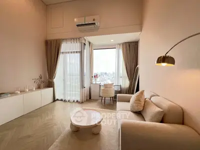 Elegant living room with city view, featuring modern furniture and large windows for natural light.