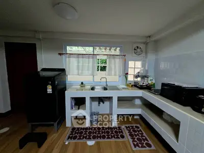 Charming kitchen with modern appliances and open layout, featuring a sleek black fridge and ample counter space.