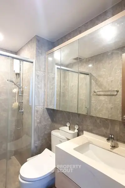 Modern bathroom with glass shower and sleek fixtures in a stylish apartment.