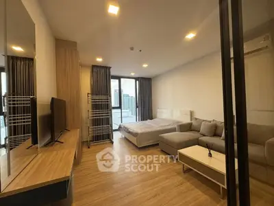 Modern studio apartment with city view, featuring cozy living area and stylish decor.